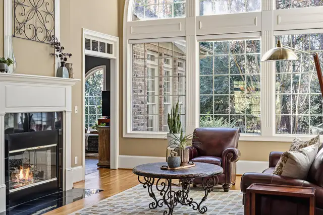 A living room with a fireplace and leather chairs